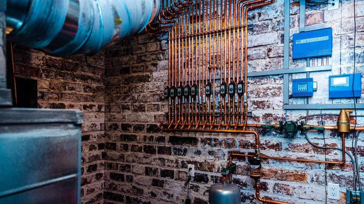 Mechanical room showing HVAC ductwork and plumbing runs